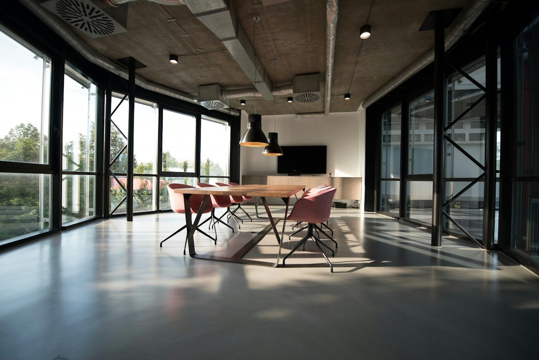 Oficina diáfana con grandes ventanales, luz natural y mesa de reuniones